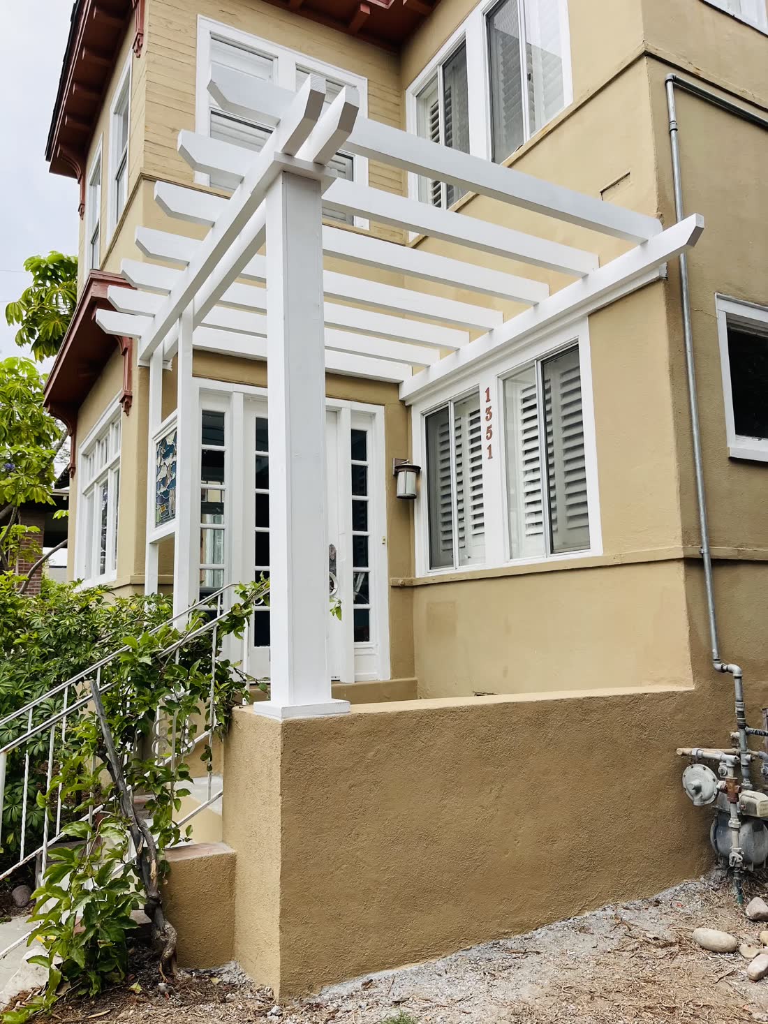 White painted pergola over a home entry